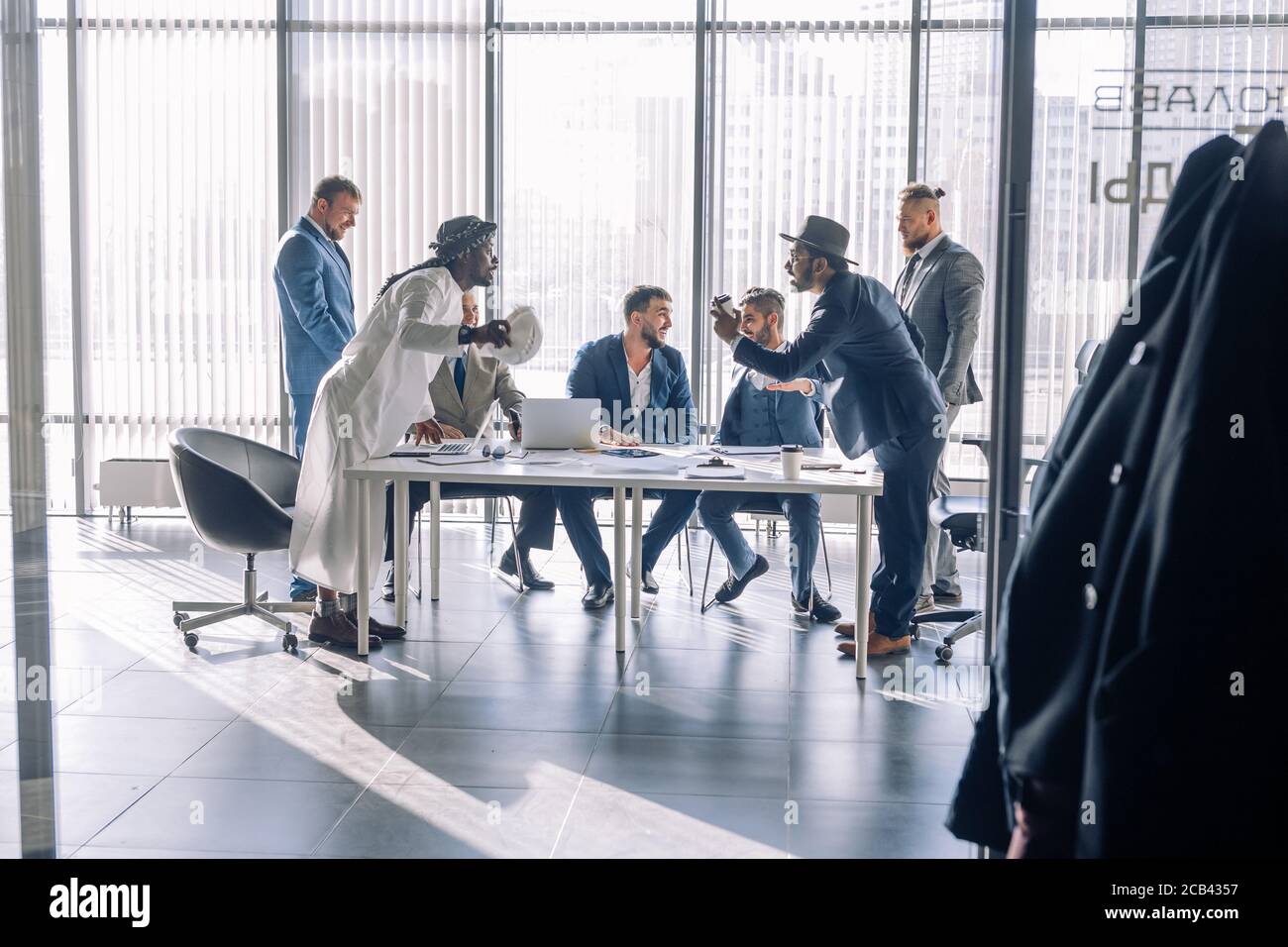 Two young Indian and Arabian business partners interacting, argue passionately, having positive