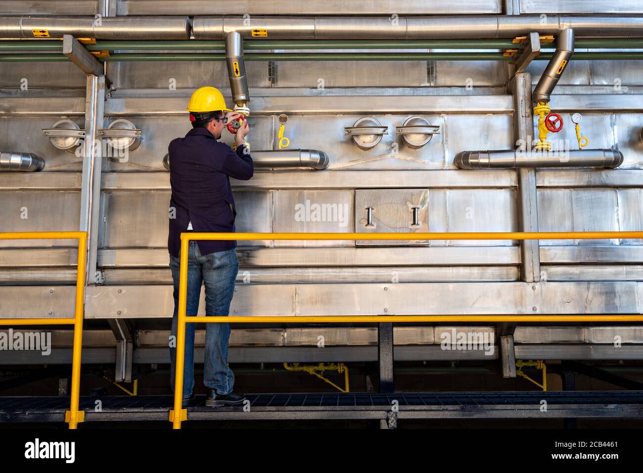 A worker adjusts the steam extraction system at the IMAG distillation