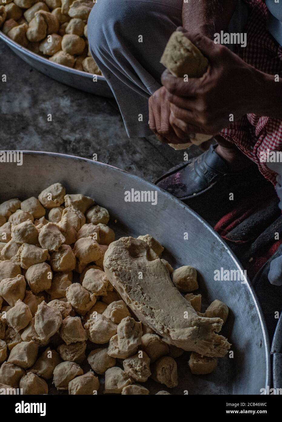 A man forming dogh to round balls in northern India Stock Photo