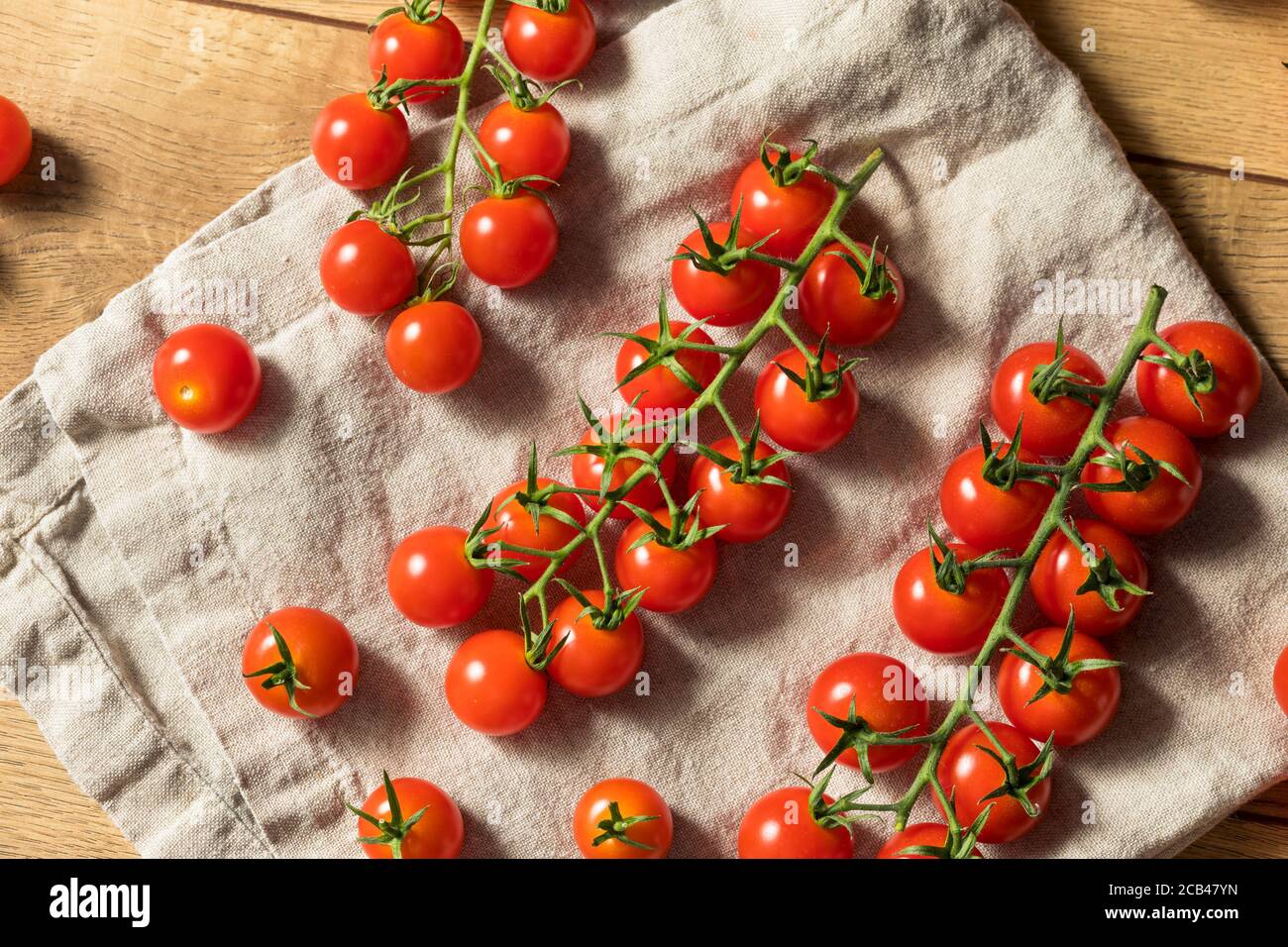 Raw Red Organic Cherry Tomatoes on the Vine Stock Photo - Alamy