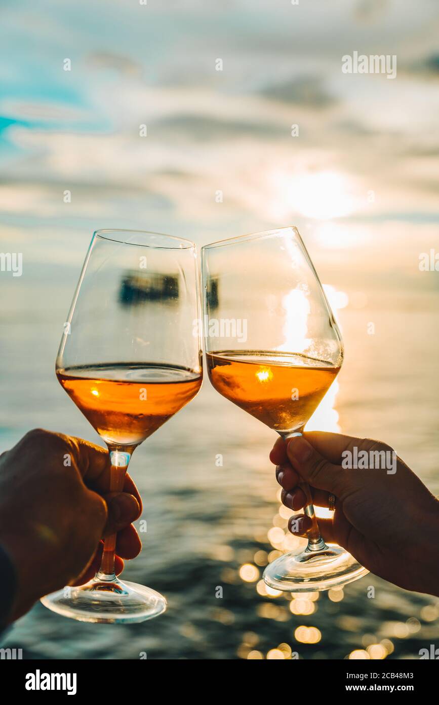 couple resting on sunset at sea beach and drinking wine Stock Photo - Alamy
