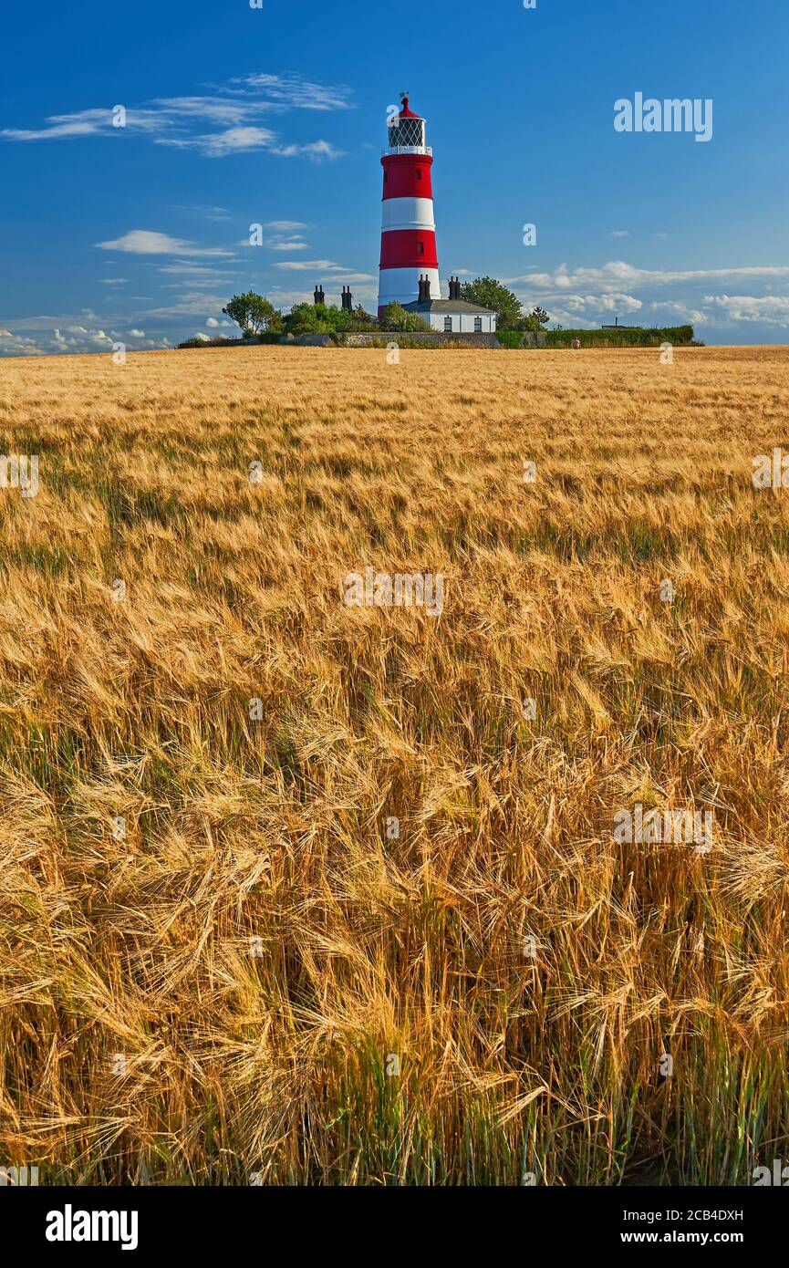 Happisburgh lighthouse Norfolk, iconic red and white striped building against a clear blue summer sky. Stock Photo