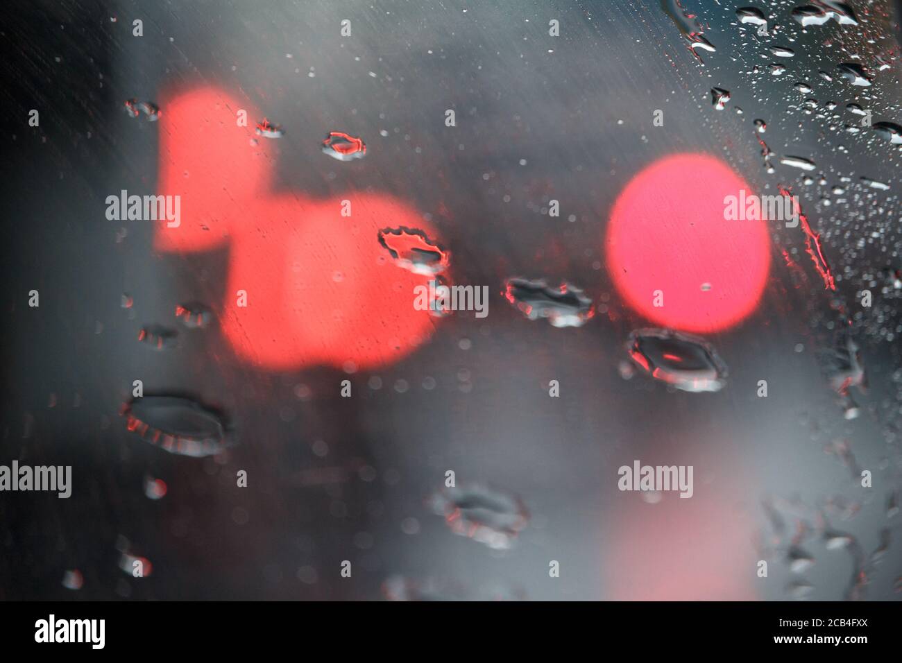 Close-up of glass with raindrops and light reflections, drops of water on car glass, selective focus Stock Photo