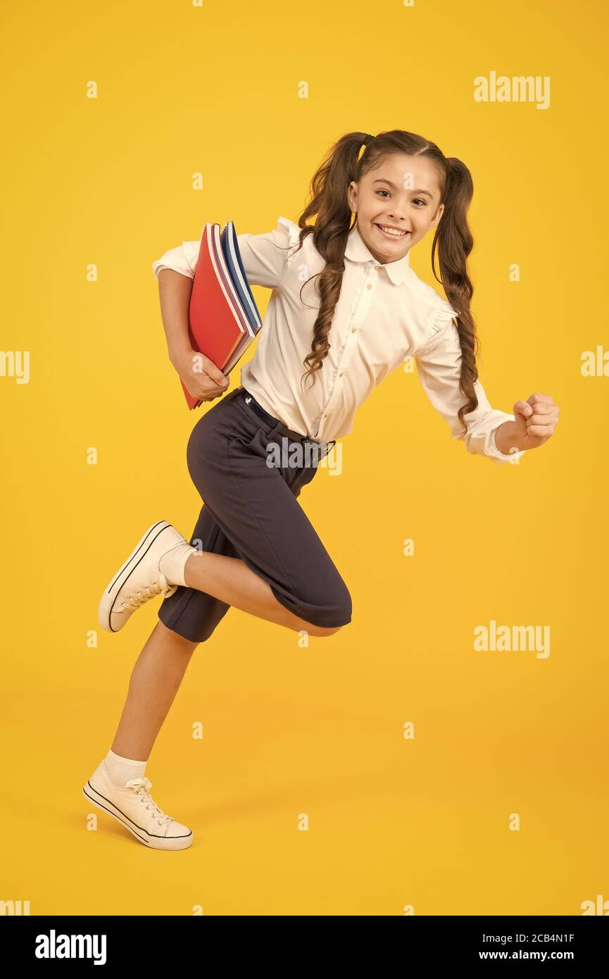 Back to school. Kid cheerful schoolgirl running. Pupil want study. Active child in motion. Beginning school lesson. Keep going. Active kid. Hurry up. Girl with books on way to school. Knowledge day. Stock Photo