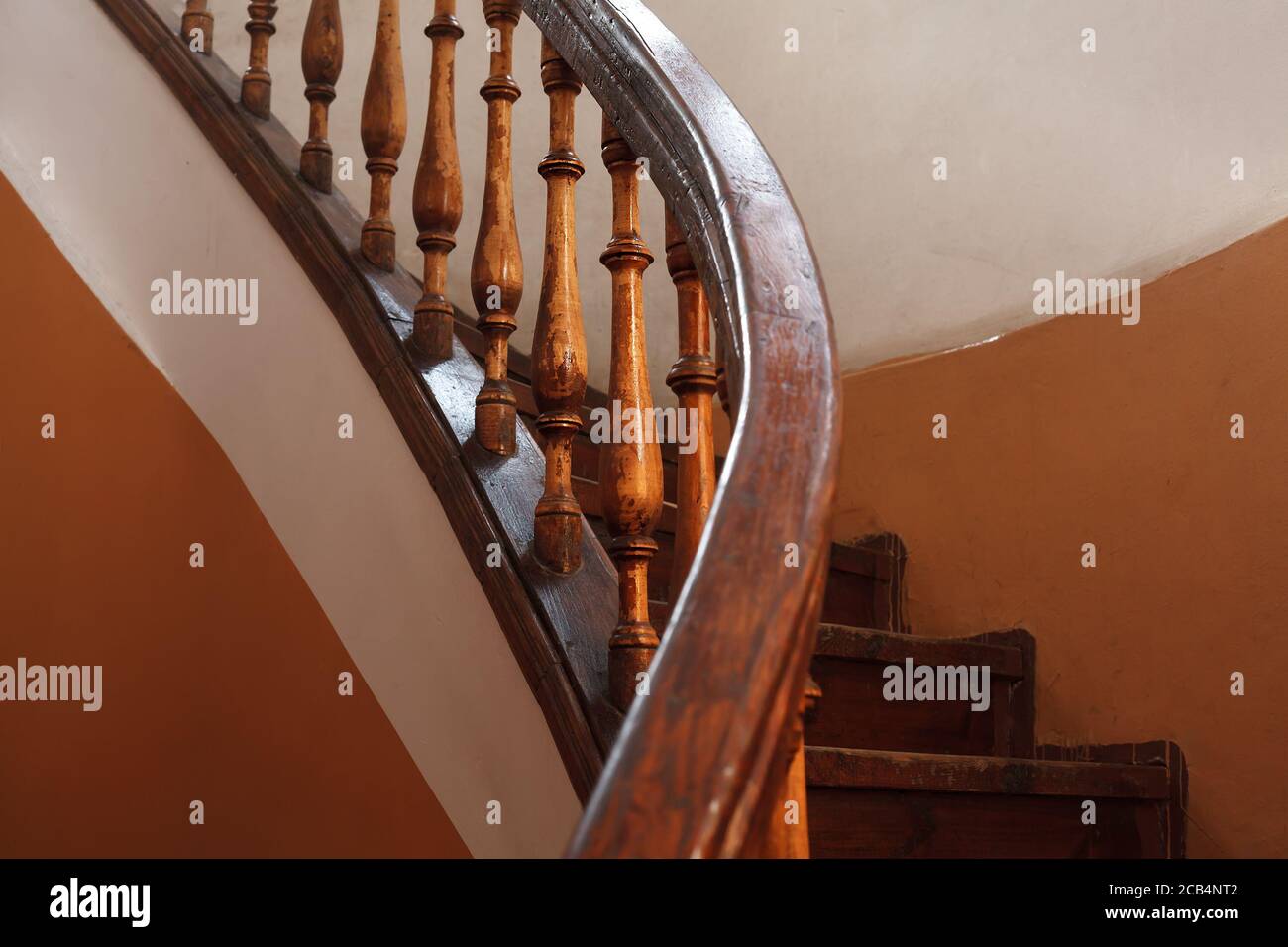 Old wooden spiral staircase railing with selective focus Stock Photo