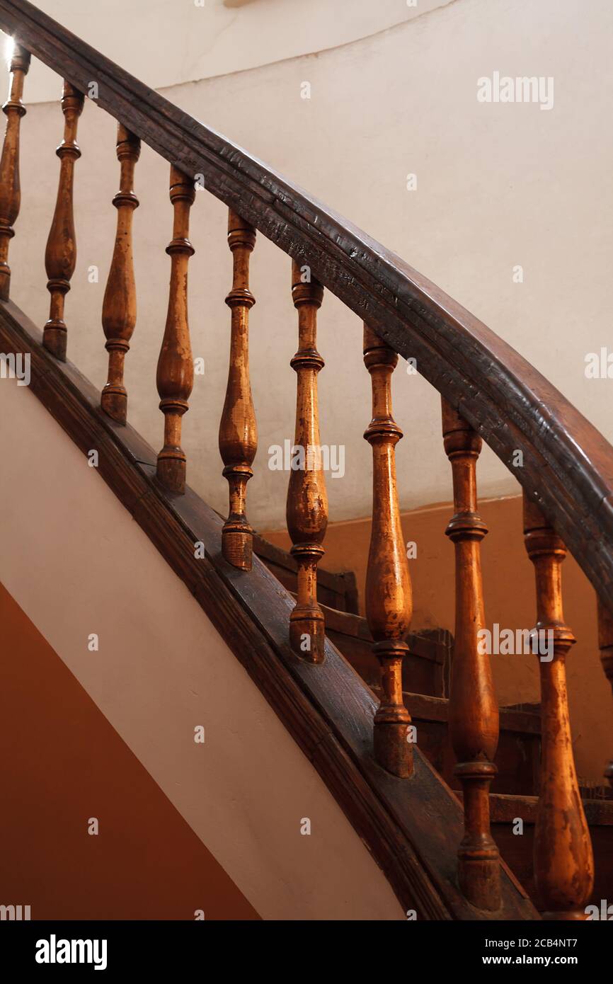 wooden spiral staircase railing with selective focus. Old house interior vertical shot Stock Photo