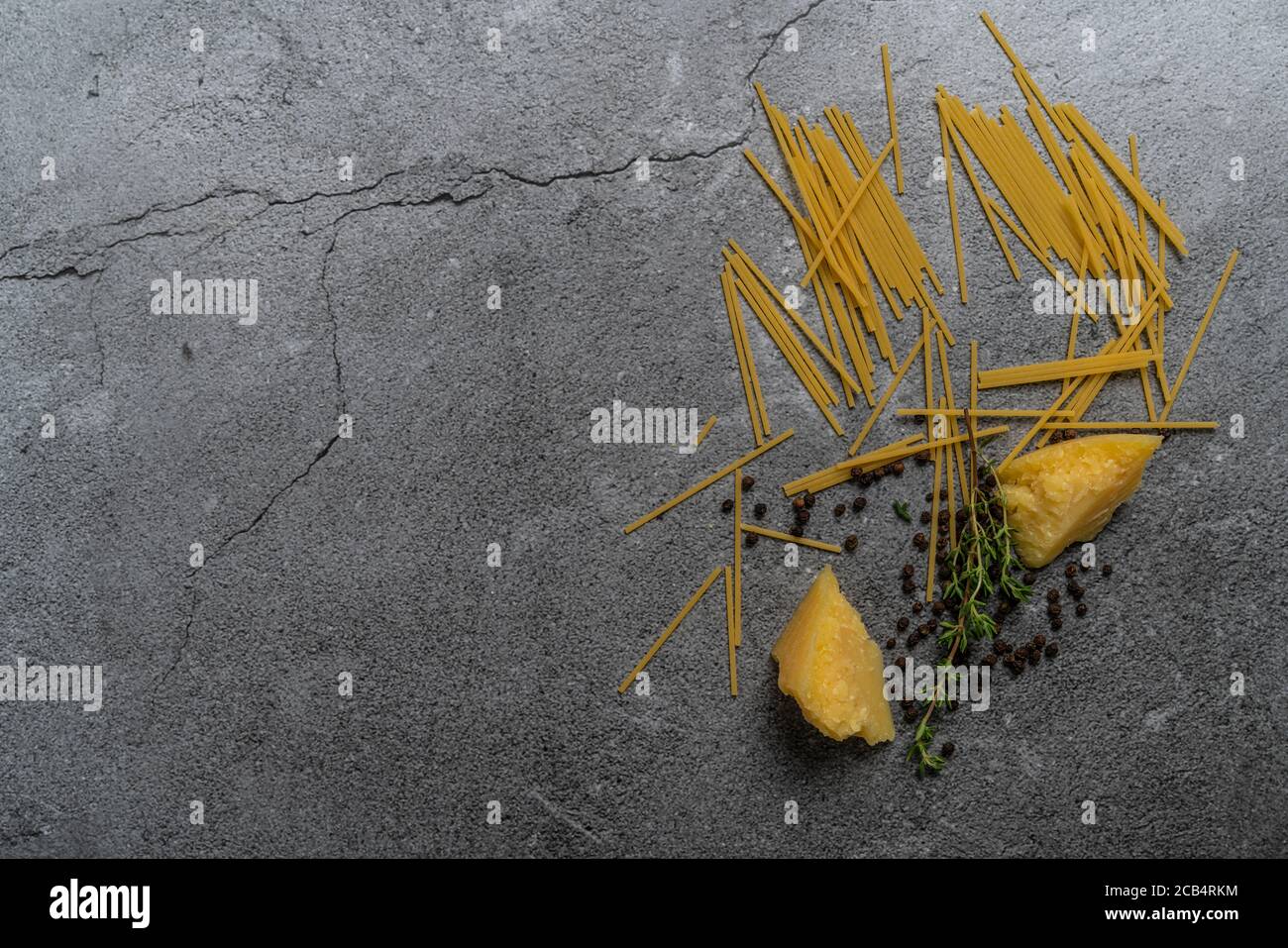 Yellow pasta on a gray background. Spaghetti on cement background. Raw spaghetti bolognese. Food background concept. Top view Stock Photo