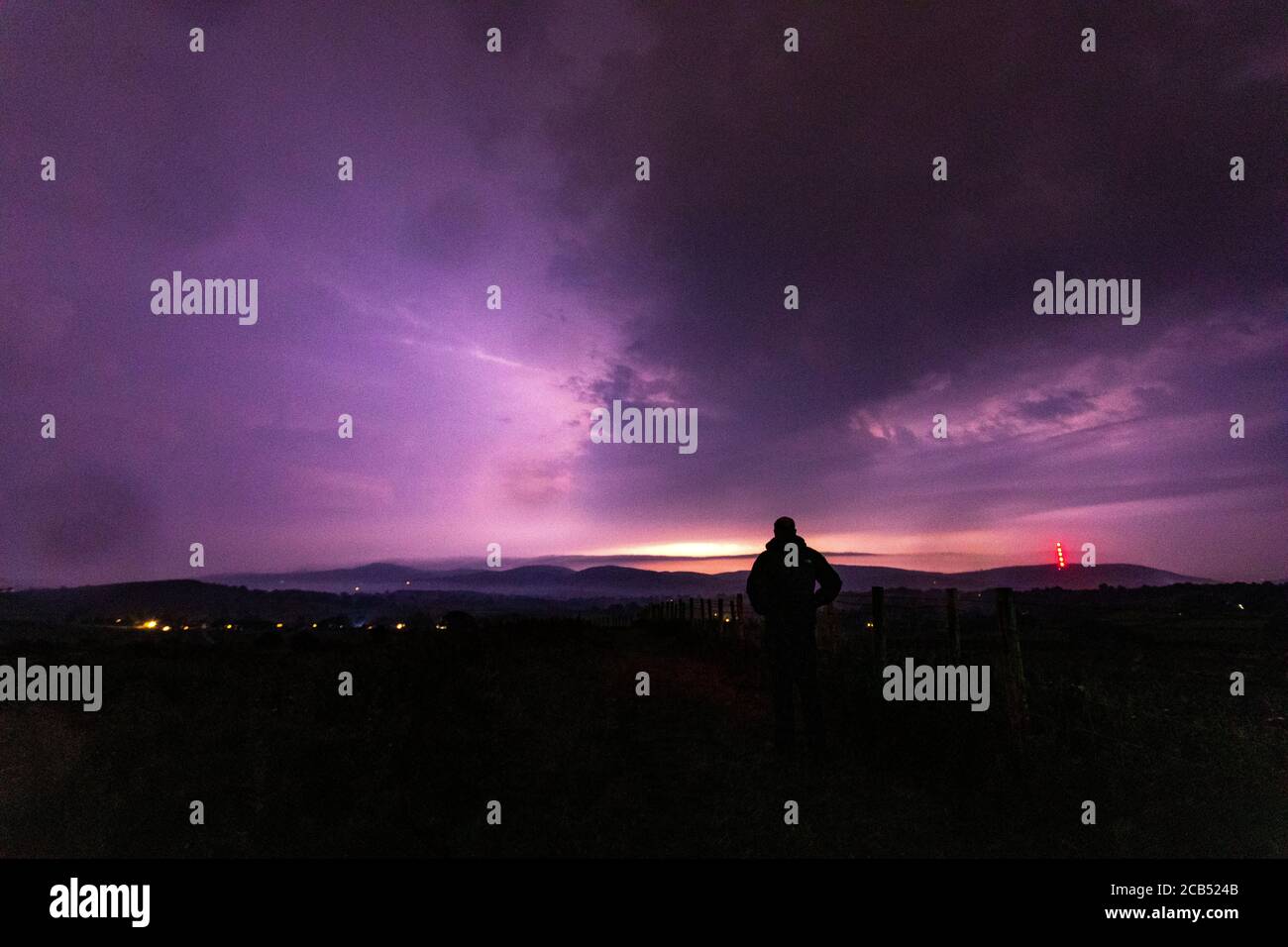 Flintshire, North Wales, 10th August 2020. UK Weather: A weather watcher watching spectacular thunder and lightning over North Wales with flooding in areas through the night as lightning strikes over the Clwydian Range © DGDImages/AlamyLiveNews Stock Photo