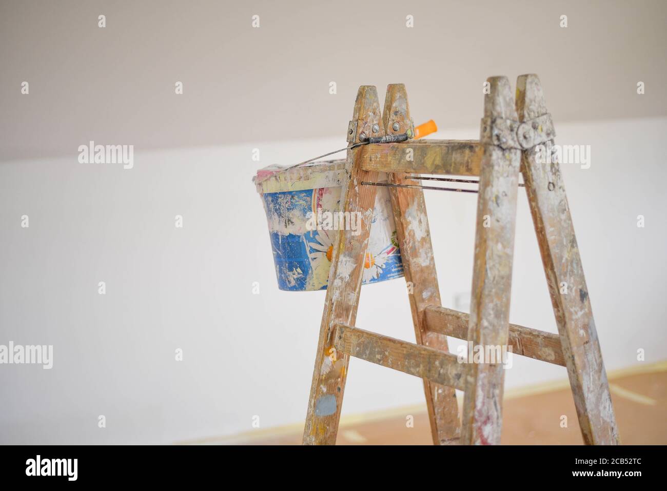 Closeup shot of a paint bucket hanging on a ladder Stock Photo