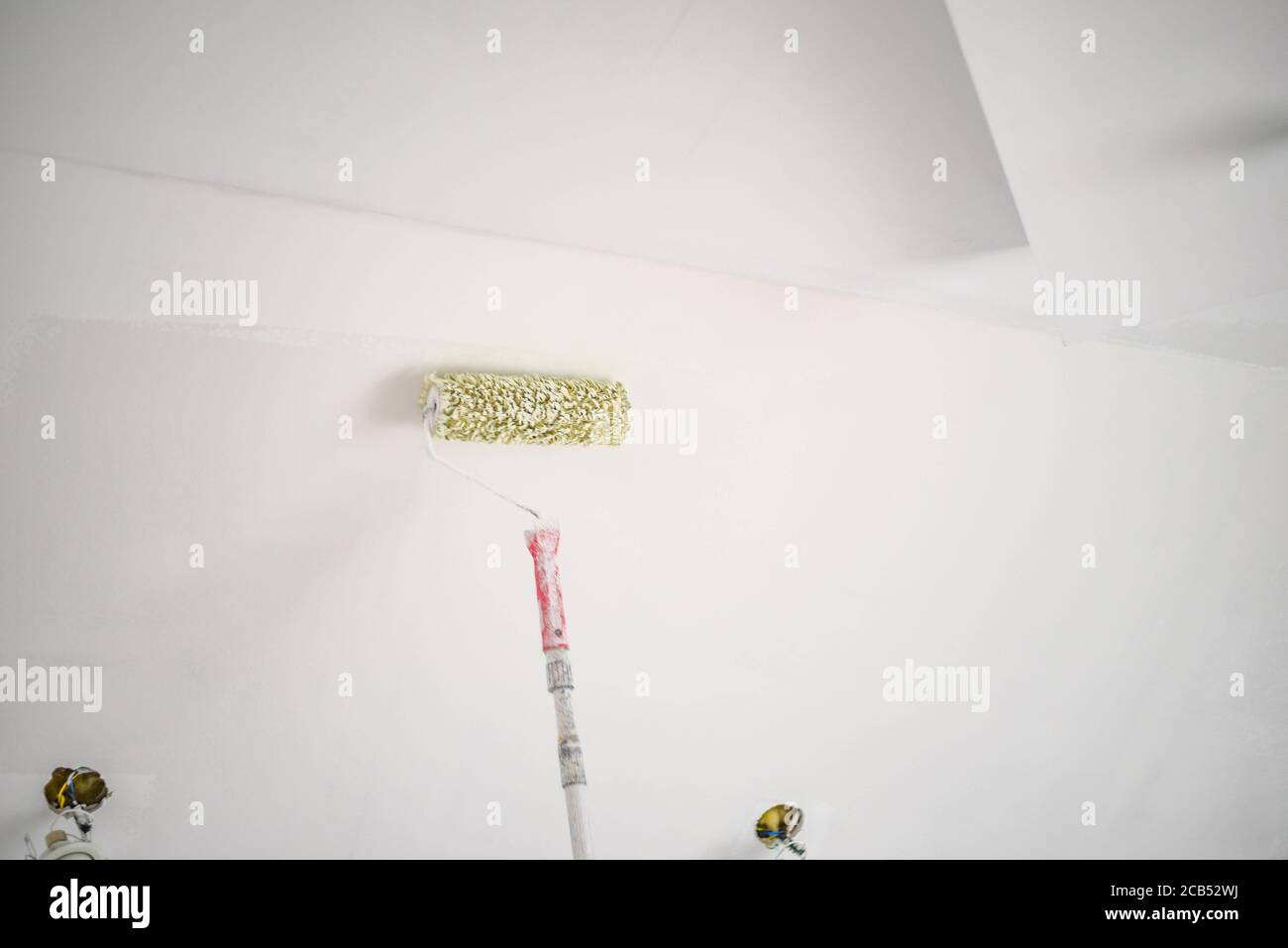Long paint roller being used on a wall Stock Photo Alamy