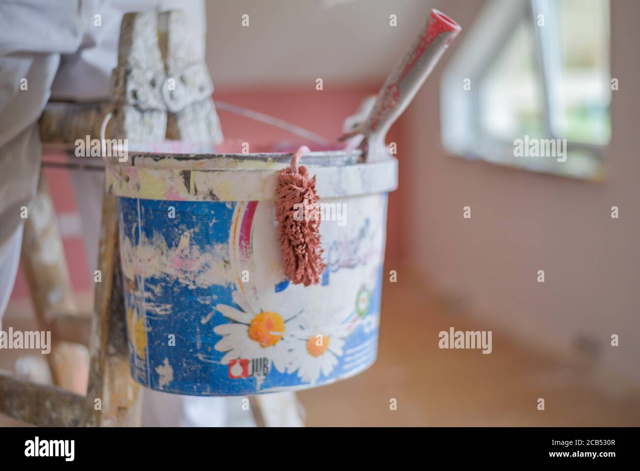 Closeup shot of a paint bucket hanging on a ladder Stock Photo