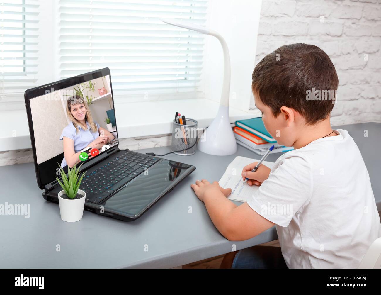 Child is having classes online, video call zoom his teacher Stock Photo ...