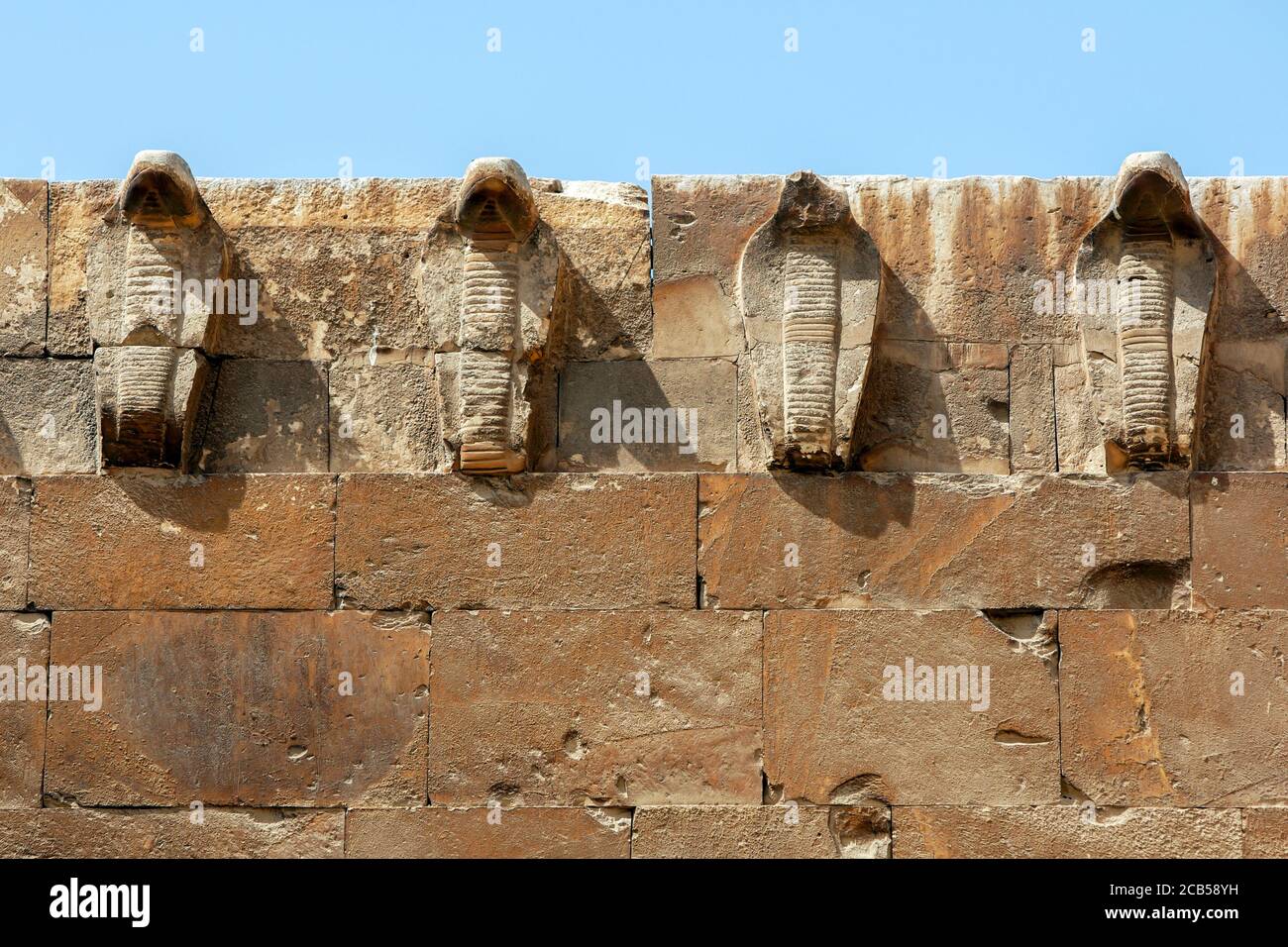 Stone carved cobra figures adorn the eastern wall of the Saqqara Necropolis in northern Egypt. Stock Photo