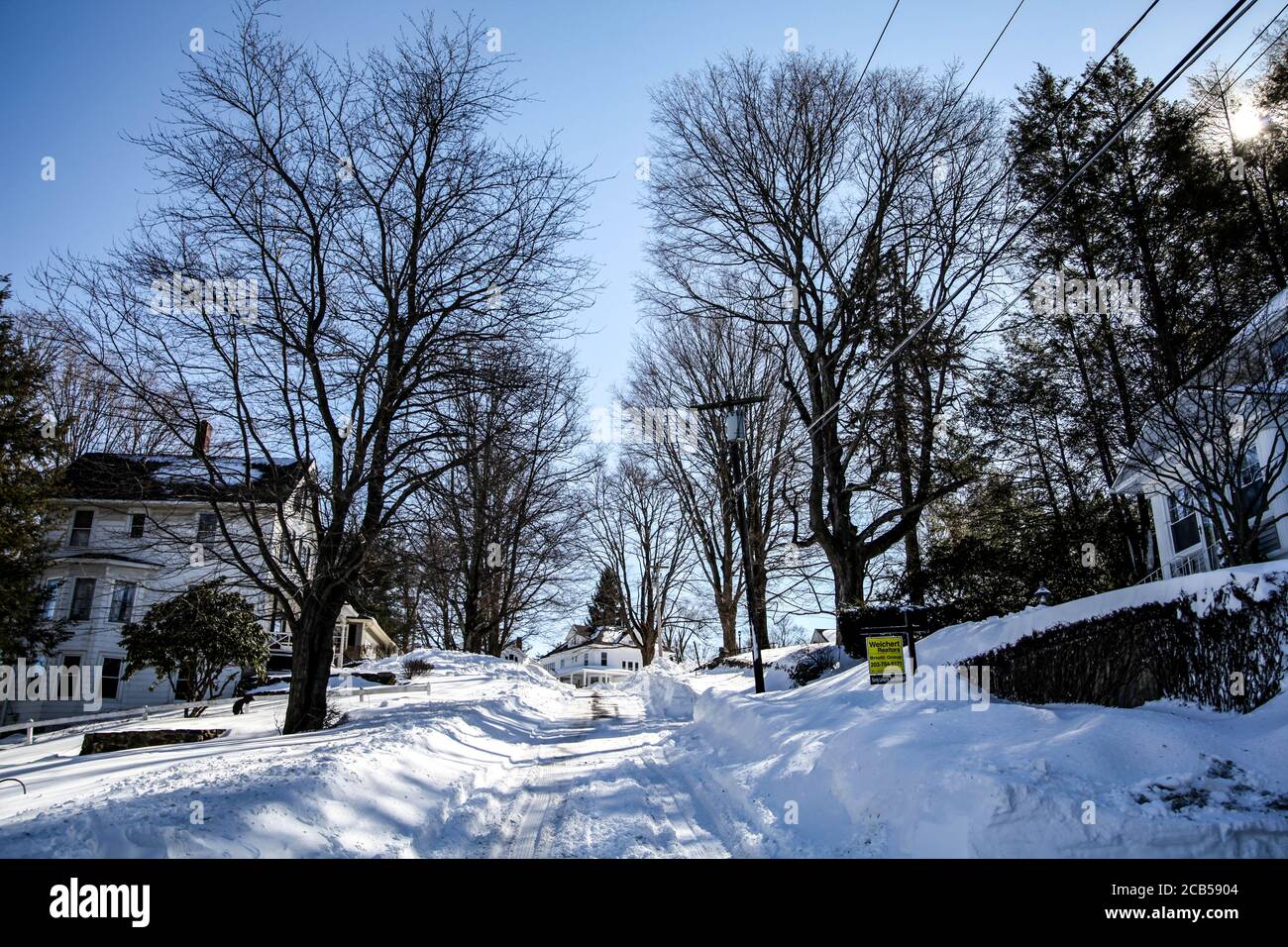 The street in the neighborhood of small town covered by snow on the next day after the snowfall Stock Photo