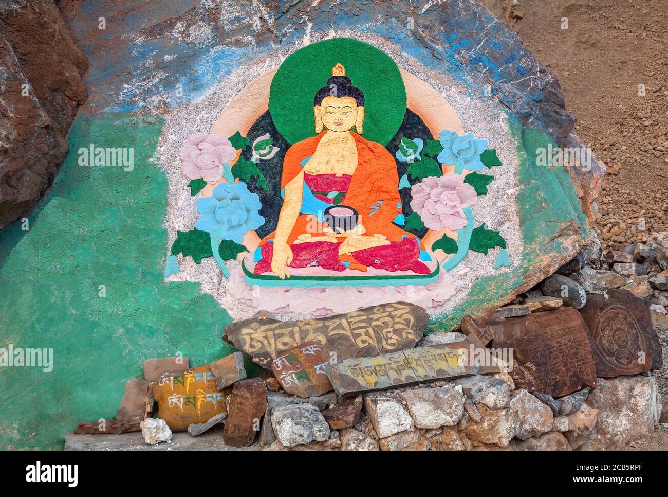 Rock painting of Buddha in a lotus position at the entrance to the ancient Buddhist Key Gompa monastery; prayer Buddhist mantras engraved on the stone Stock Photo