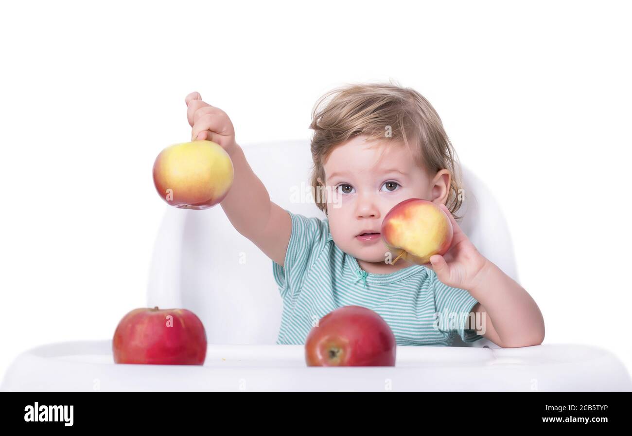 An adorable baby playing with apples on an isolated background Stock Photo