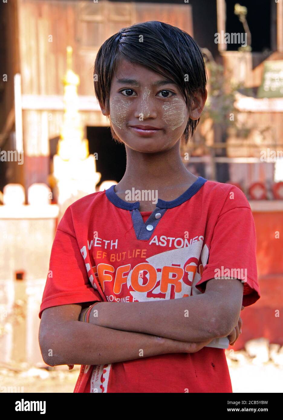 Mandalay, Myanmar - January 31, 2010: close up portrait of unidentified young woman with tanaka paste on her face on a city street on a sunny day Stock Photo