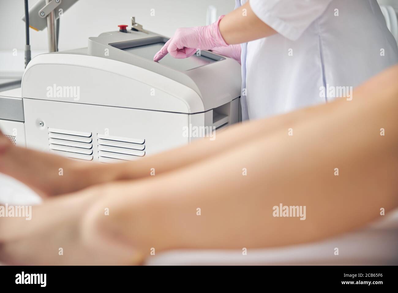 Doctor preparing for conducting the laser leg hair removal procedure Stock Photo