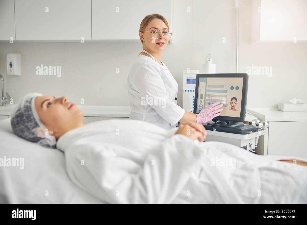 Pleased cosmetologist in eyeglasses posing for the camera Stock Photo