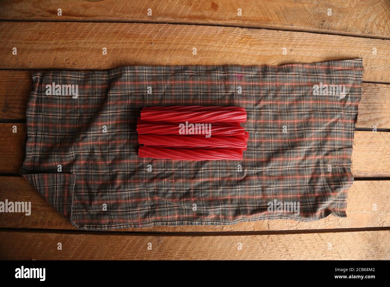 High angle shot of a bunch of stick candies on a cloth on a wooden surface Stock Photo