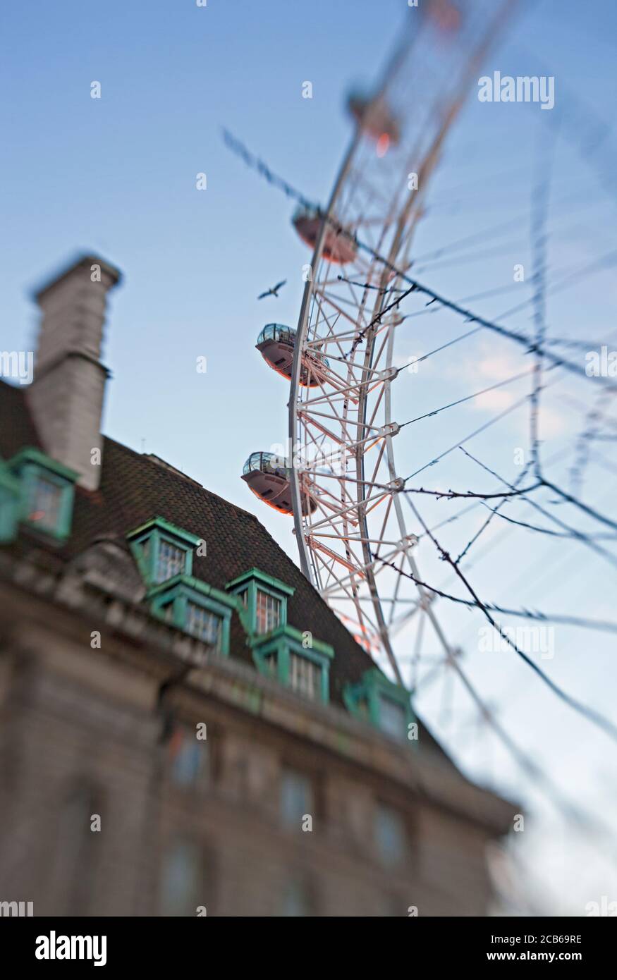 The giant London Eye Ferris wheel looms over a building Stock Photo