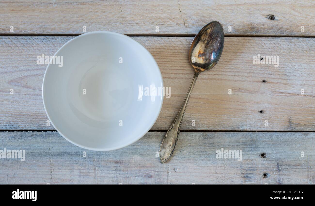 Bowl and spoon on used look wooden background. Stock Photo