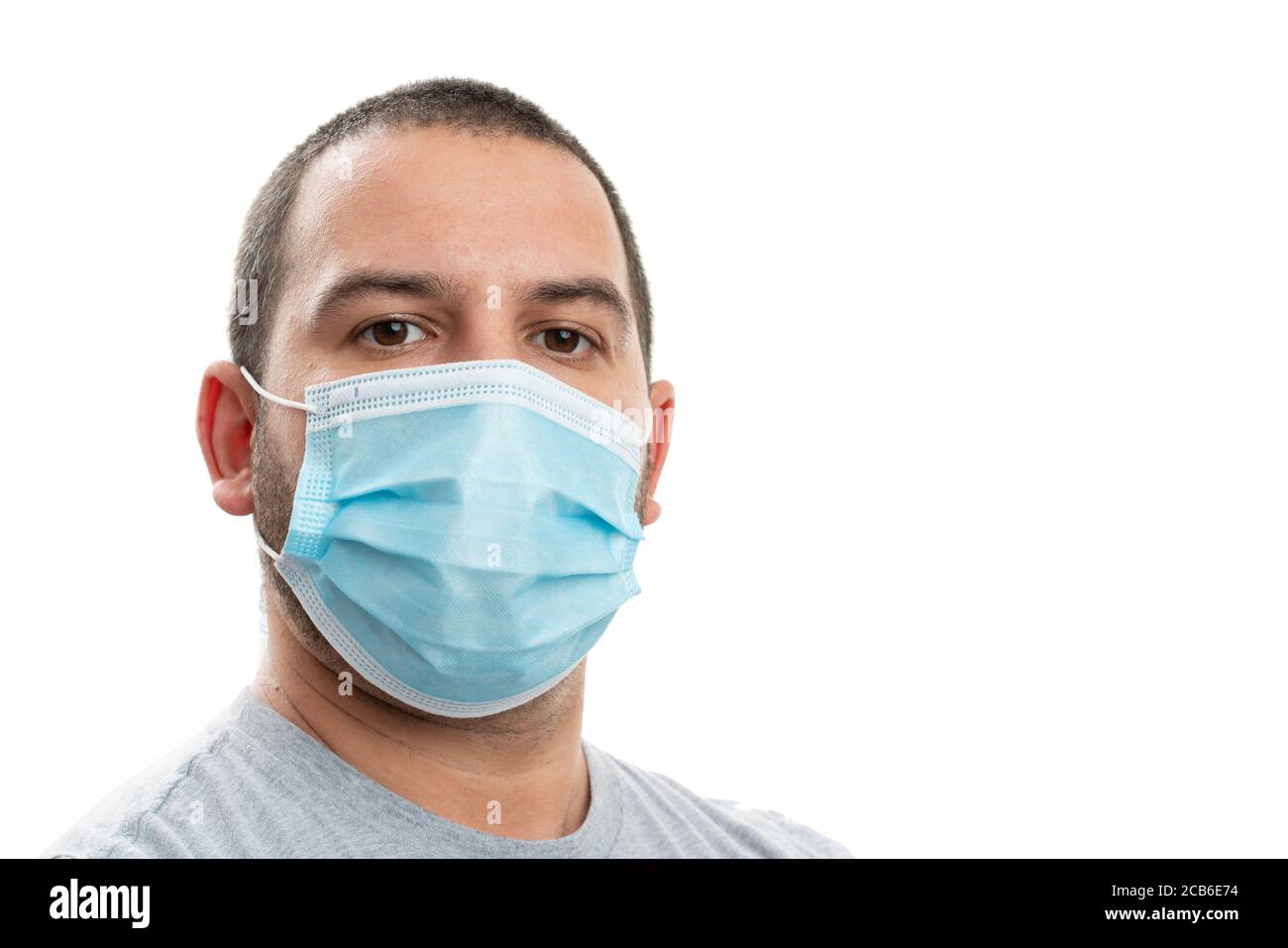Close-up portrait of white adult man wearing disposable medical or surgical mask as covid19 infection prevention concept with blank copyspace for adve Stock Photo