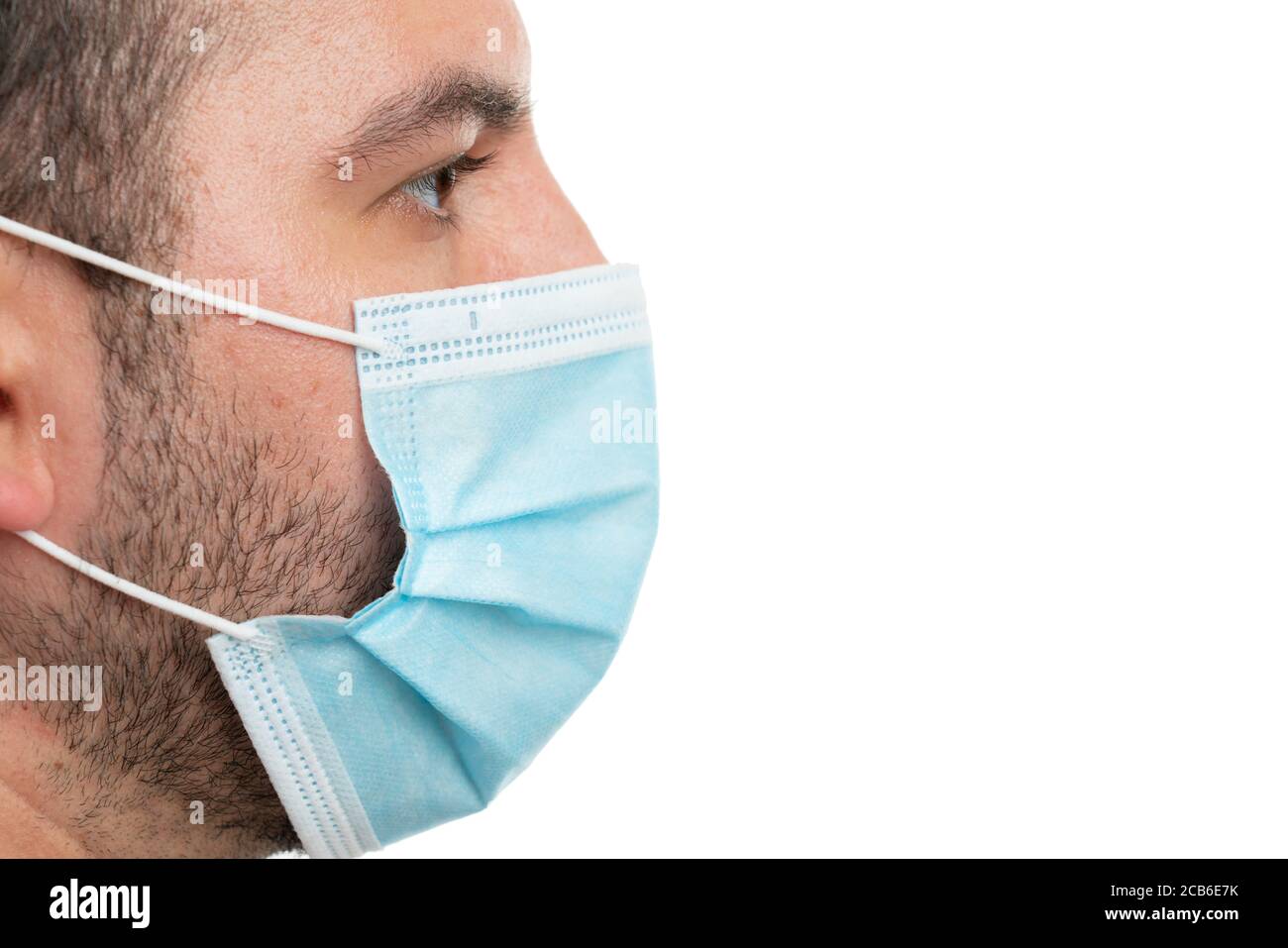 Close-up side view of white adult face covering mouth and nose using covid19 protective disposable medical mask  with blank copyspace for text isolate Stock Photo