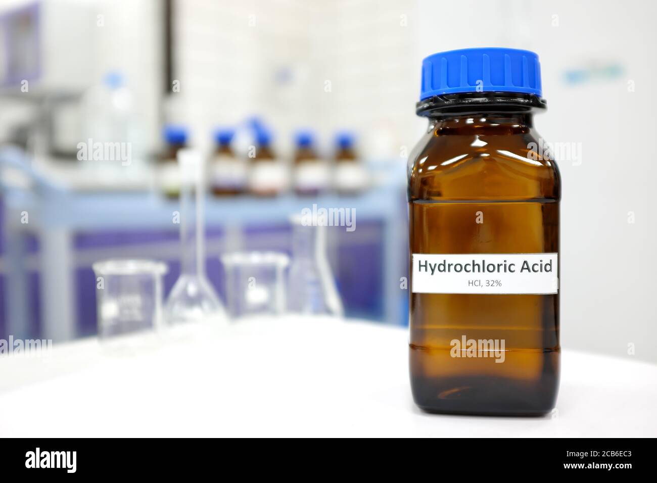 Selective focus of strong Hydrochloric acid solution in brown amber bottle. Blur laboratory backdrop with copy space. Stock Photo