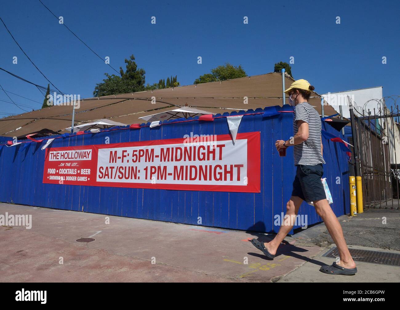 Los Angeles, United States. 10th Aug, 2020. A man walks past a bar informing customers that it will be open during weekends outdoors on their patio after Los Angeles County officials barred indoor ding at restaurants and bars following a spike in COVID-19 cases in the Silver Lake area of Los Angeles on Monday, August 10, 2020. 'Simply put, closing the bars worked,' said Ferrer. Credit: UPI/Alamy Live News Stock Photo
