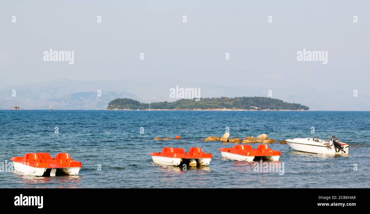 Leisure boats moored on Corfu coast with Albanian coastline in distance Stock Photo