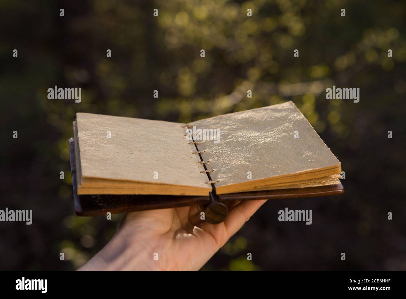 Opened old book with reflected in black surface. Stock Photo