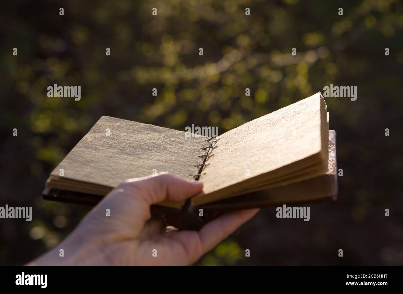 Opened old book with reflected in black surface. Stock Photo
