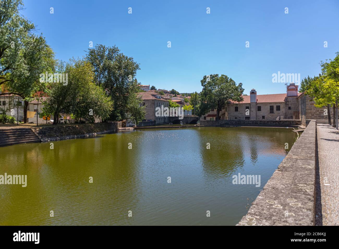 Viseu / Portugal - 07/31/2020 : View at the Viseu city downtown, with the Paiva river , classic buildings and Church of Mercy on top Stock Photo