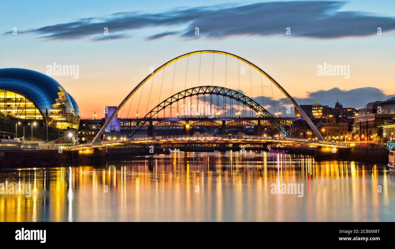 Looking up the River Tyne towards the iconic Tyne, Millennium and High Level Bridges. Captured at sunset with reflections in the water. Stock Photo