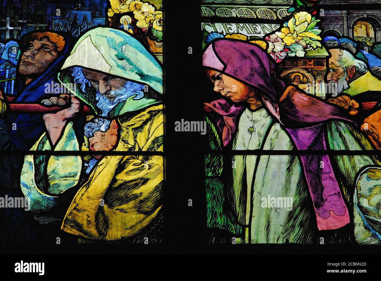 Pallbearers: St Methodius carries the casket of his brother, St Cyril, in this scene from the Lives of Cyril and Methodius, designed in 1930s stained glass by renowned Art Nouveau artist Alphonse Mucha for the New Archbishop’s Chapel in the Cathedral of St Vitus in Prague, Czechia / Czech Republic. The saints, missionaries to Moravian Slavs, encouraged Christianity by translating the Bible into a language understood by Slavs and by creating a Slavic alphabet to transcribe it. Alphonse or Alfons Maria Mucha (1860-1939) was a prolific painter, illustrator and graphic artist. Stock Photo