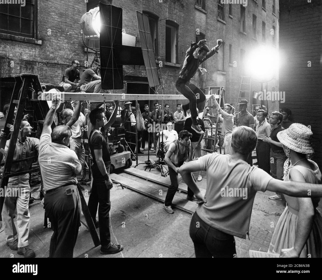 Director ROBERT WISE (seated at centre) on set candid directing GEORGE CHAKIRIS in dance number on location in New York for WEST SIDE STORY 1961 directors JEROME ROBBINS and  ROBERT WISE music Leonard Bernstein lyrics Stephen Sondheim A Robert Wise Production / The Mirisch Corporation / United Artists Stock Photo
