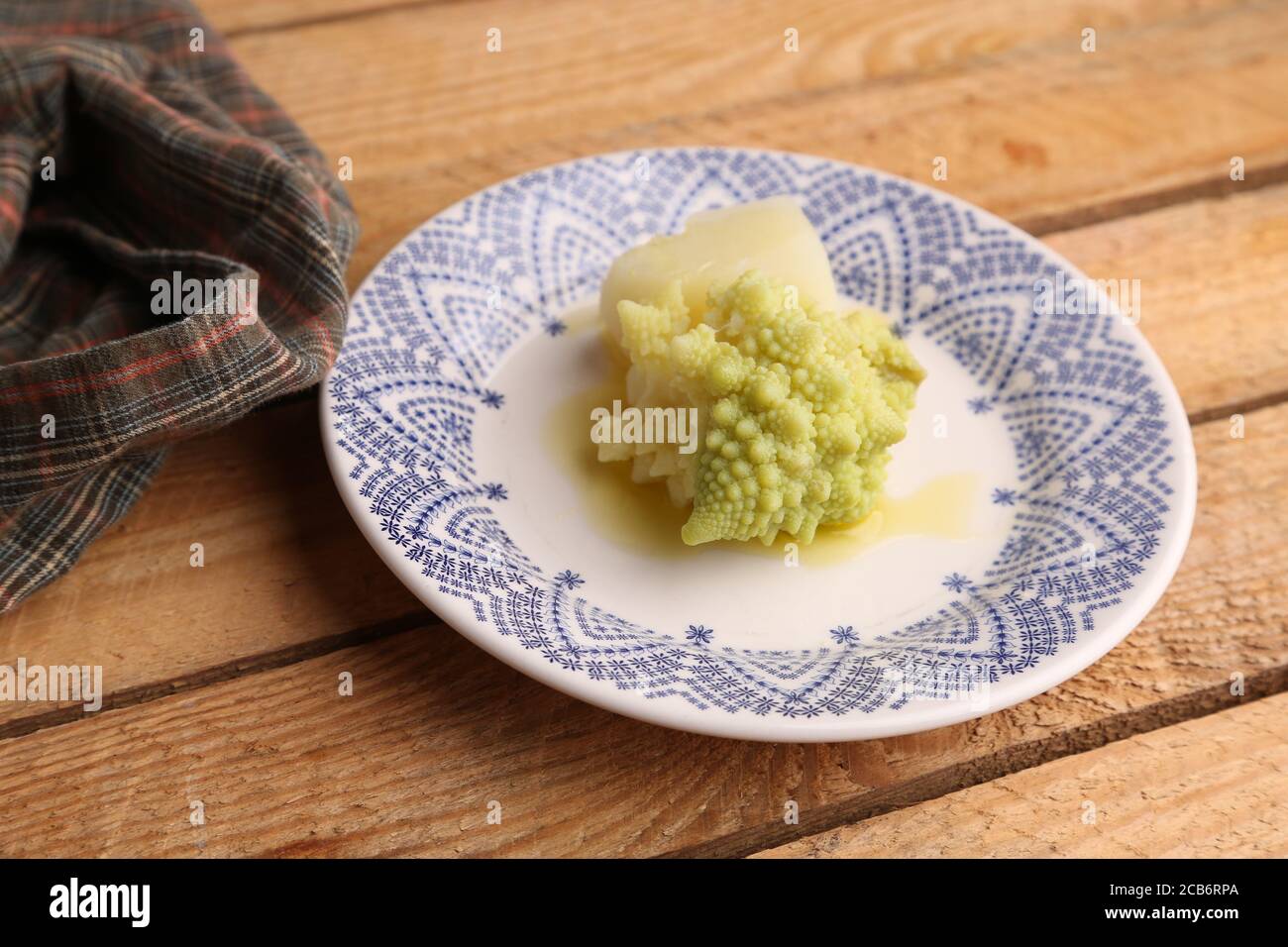 Closeup of cooked Romanesco broccoli in a plate on a wooden table Stock ...