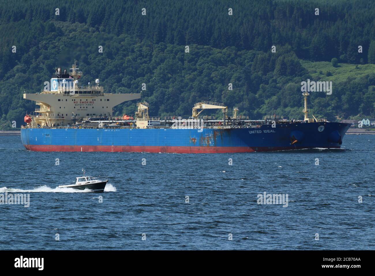 United Ideal, an oil tanker operated by Marine Management Services, off Gourock on the Firth of Clyde, being passed by the cabin cruiser Diligence. Stock Photo