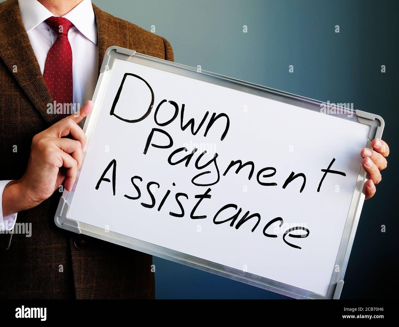 Banker shows the inscription Down payment assistance. Stock Photo