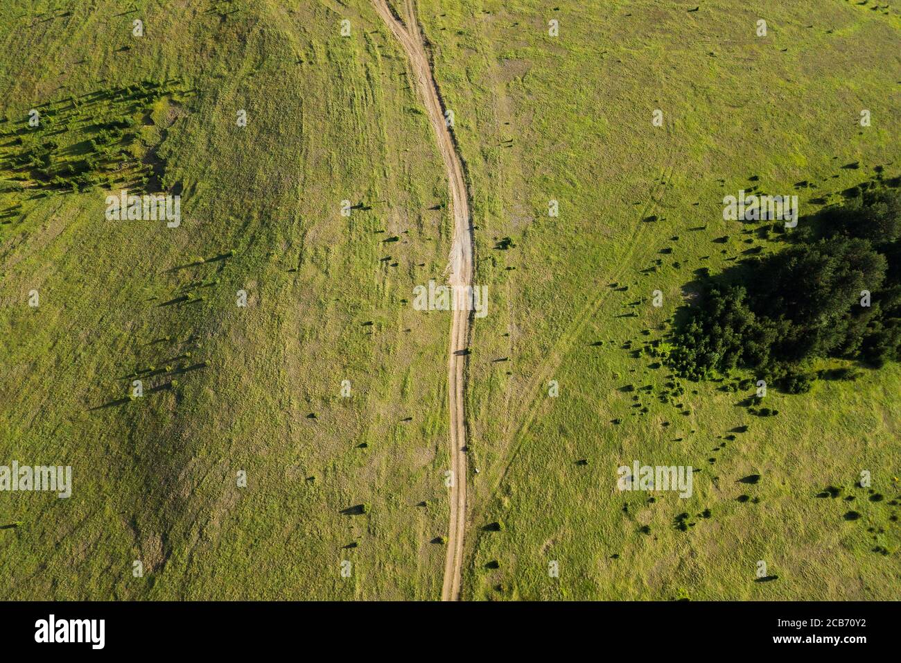 Aerial view of a dirt road going through mountain planes Stock Photo