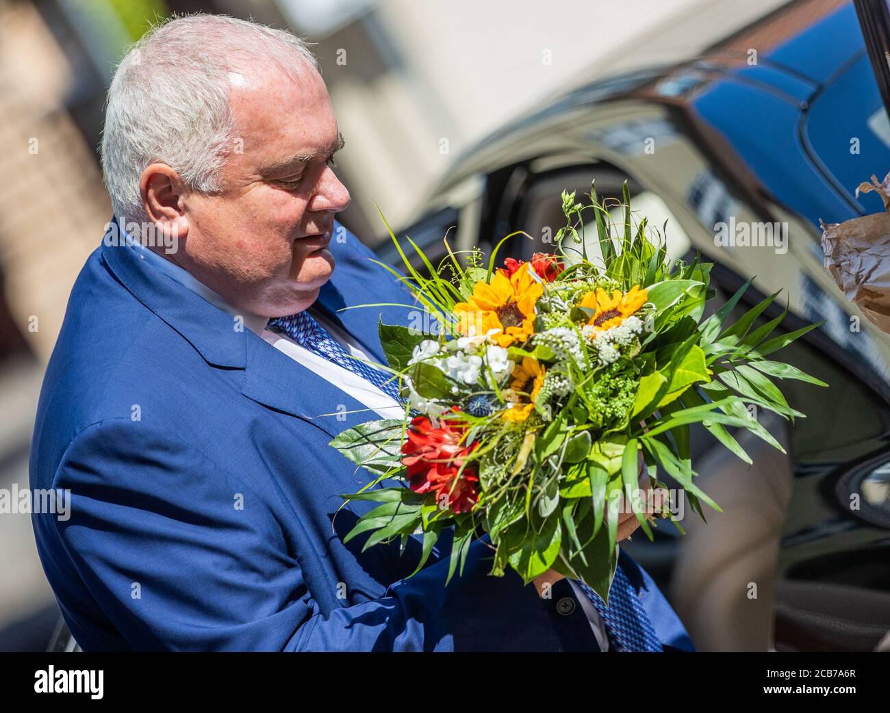 Schwerin, Germany. 11th Aug, 2020. Matthias Warnig, Managing Director of Nord Stream 2 AG, wraps a bouquet of flowers out of paper before a meeting with the Prime Minister of Mecklenburg-Vorpommern, Schwesig, in the State Chancellery. The situation surrounding the pipeline construction has become even more acute due to threats made by individual US senators against the port of Sassnitz last week, according to the State Chancellery. Schwesig wants to discuss the situation with company representatives and explore possibilities to successfully complete the project. Credit: Je/dpa/Alamy Live News Stock Photo