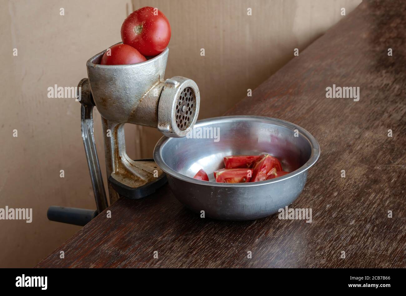 Manual vintage meat grinder and ripe tomatoes on the table. Making homemade  tomato sauce. Use of outdated kitchen utensils Stock Photo - Alamy