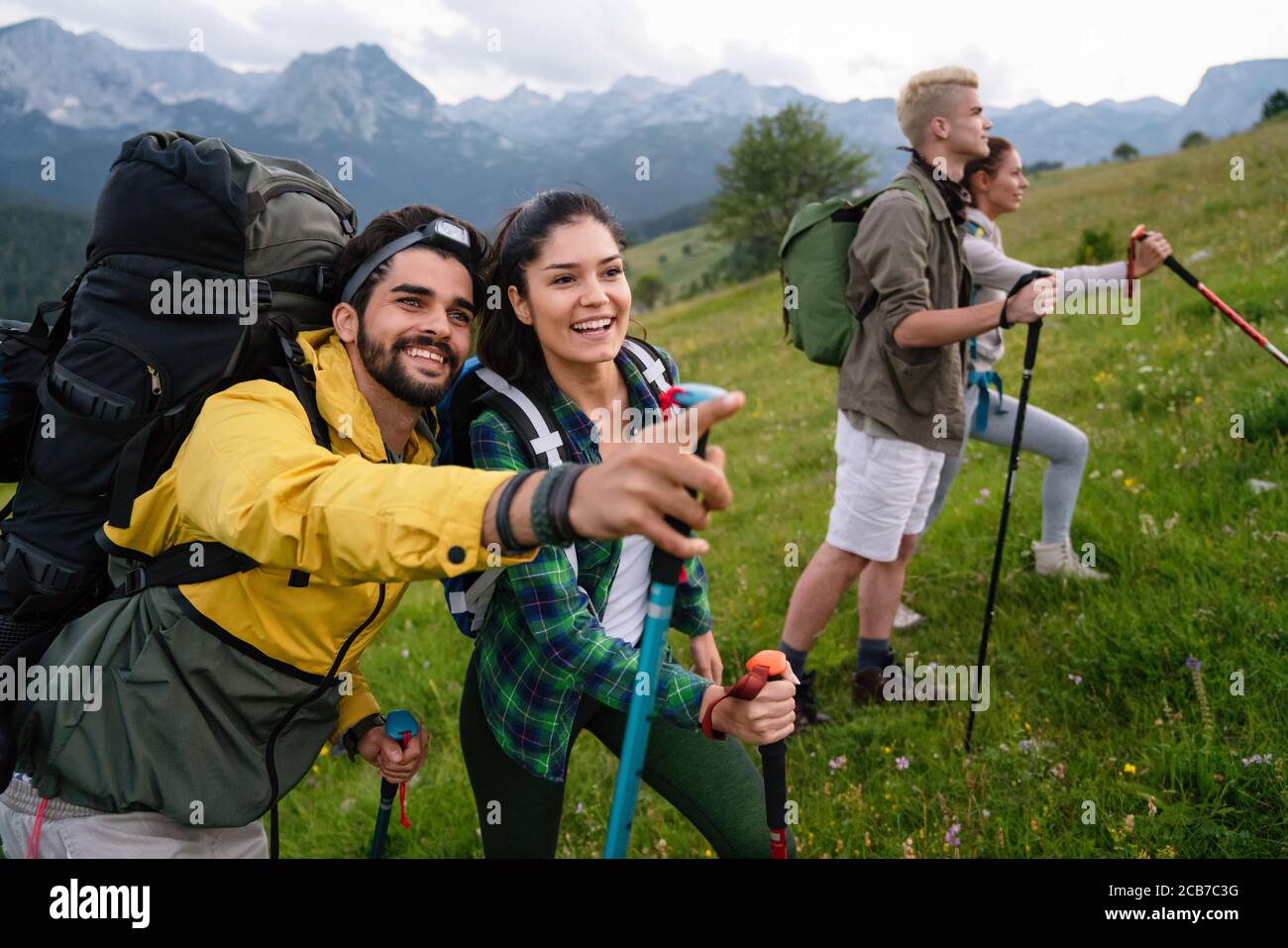 Group of young friends hiking in countryside. Multiracial happy people ...