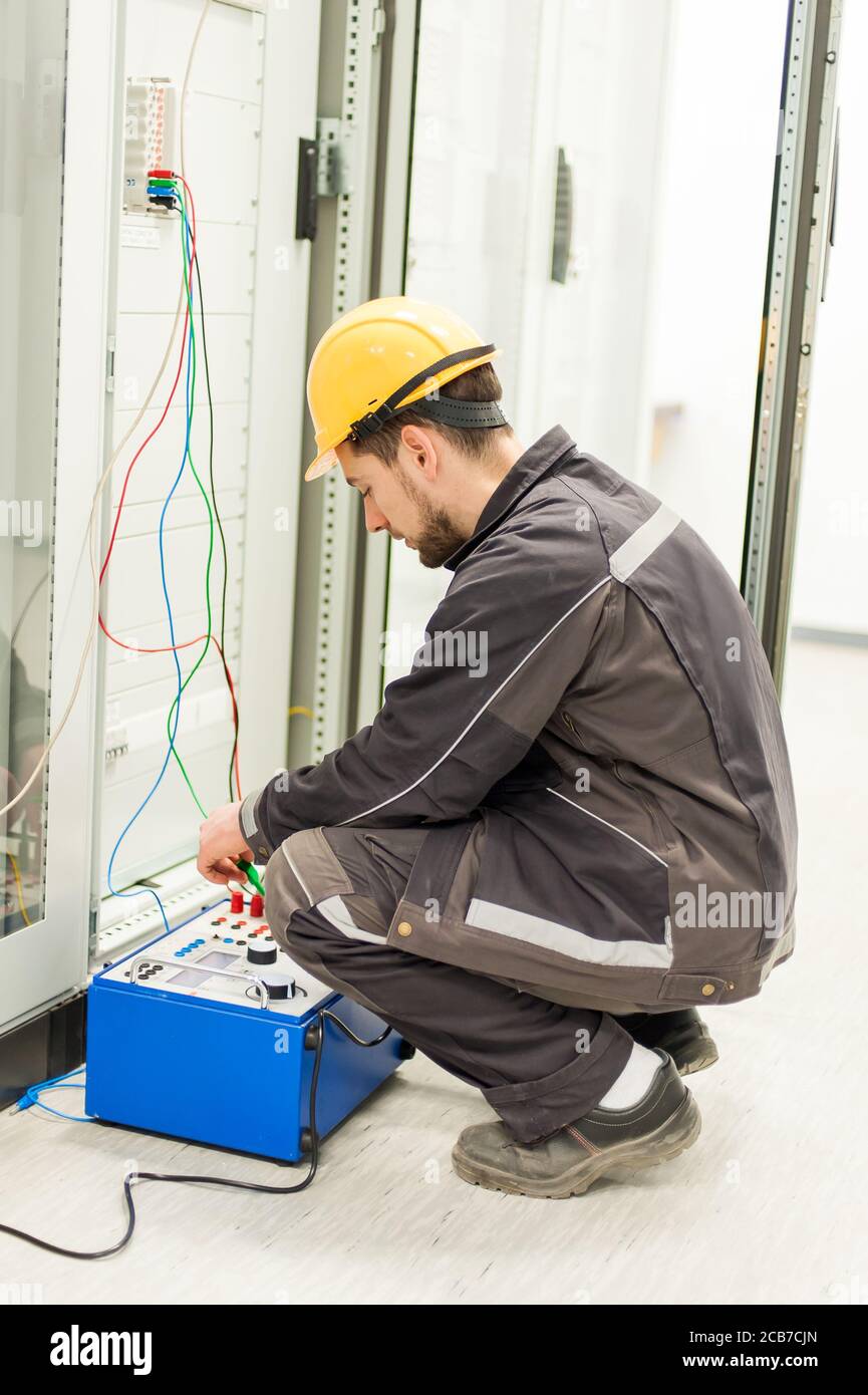 Electrician engineer tests system with relay test set equipment. Relay