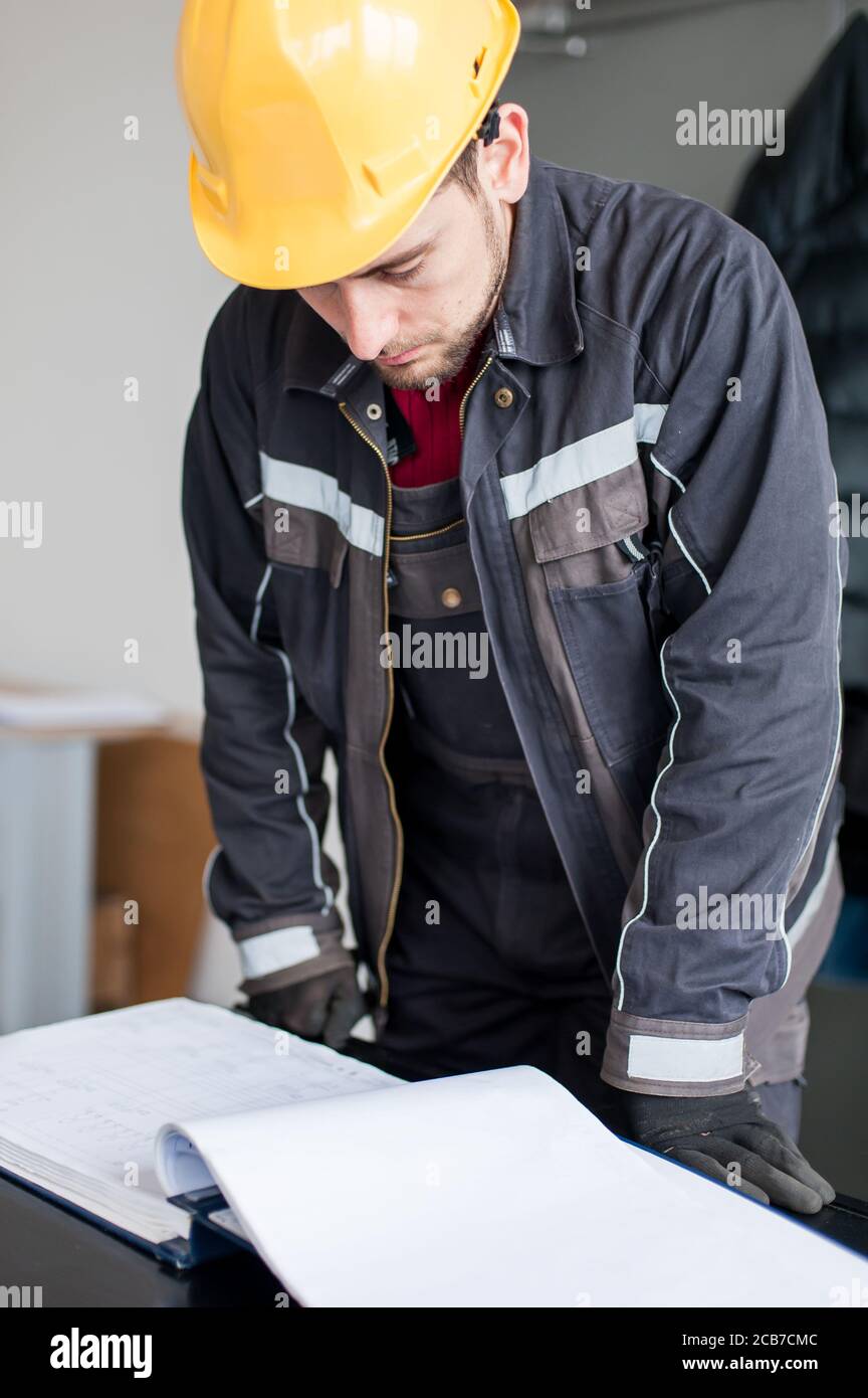 Maintenance engineer interprets and looks at project plans on relay