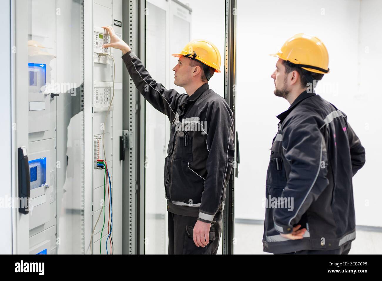 Field service crew testing electronics or inspecting electrical installation system. Bay control unit. Medium voltage switchgear Stock Photo