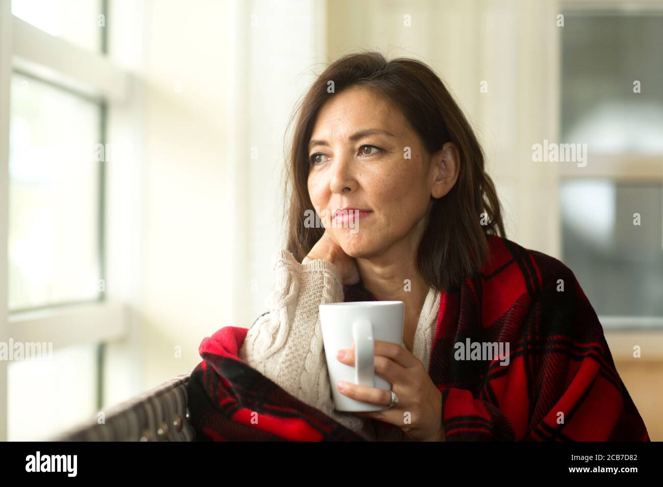 Mature Asian woman enjoying a cup of coffee. Stock Photo