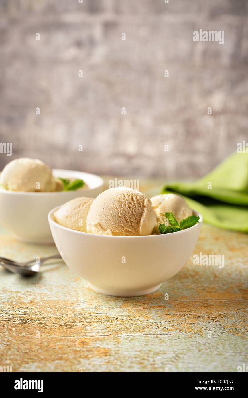 Vanilla ice cream in white bowls on pastel background Stock Photo