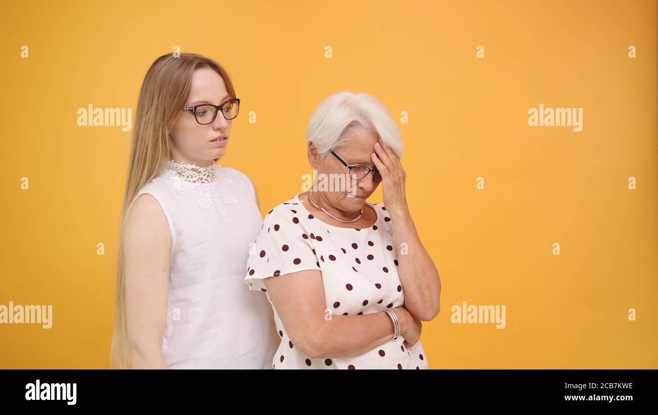 Young woman calming down senior lady after bad news. Family love and care concept. High quality photo Stock Photo